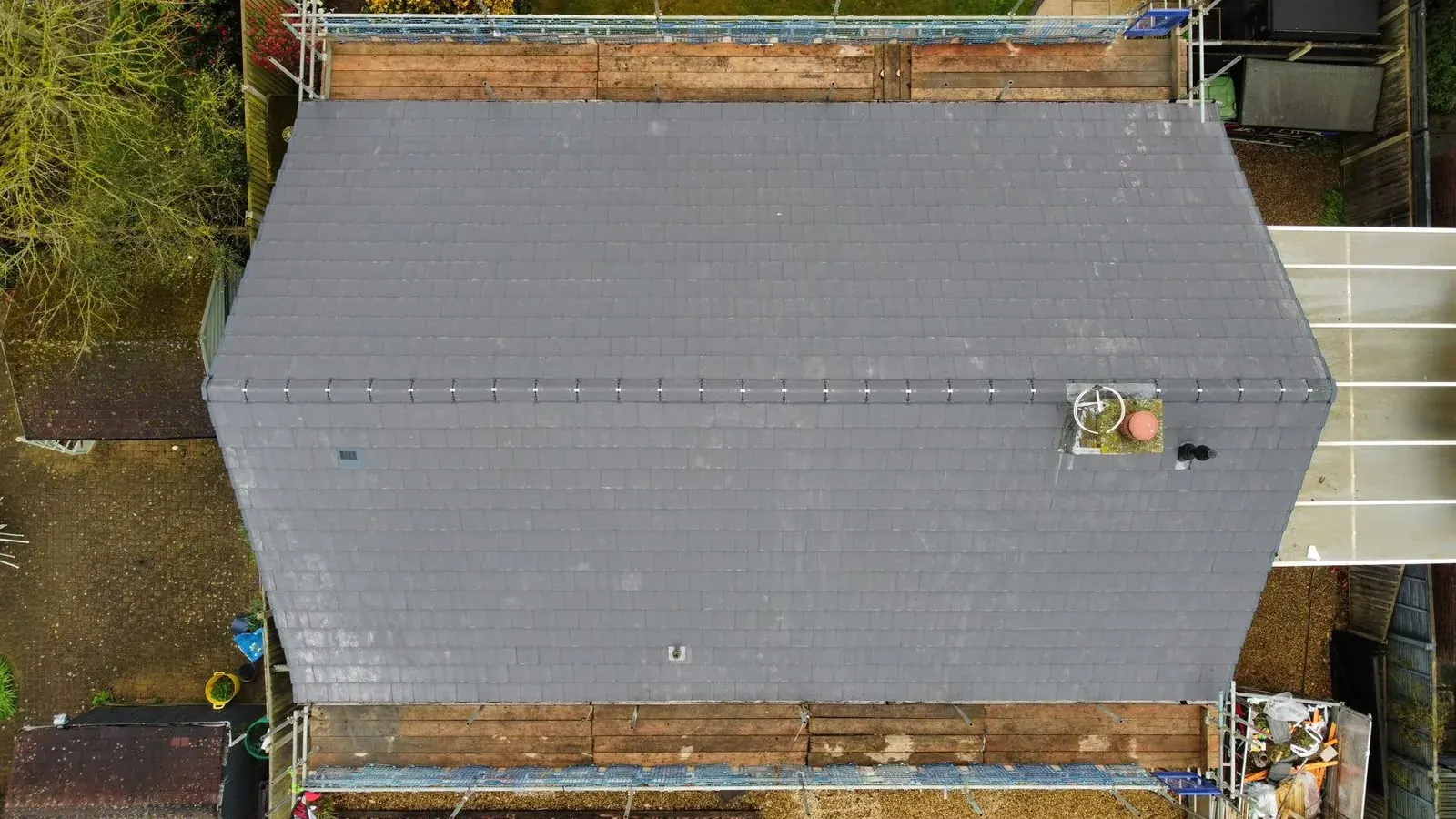 Drone view of a new grey tile roof with dry ridge system by DJW Roofing & Leadwork