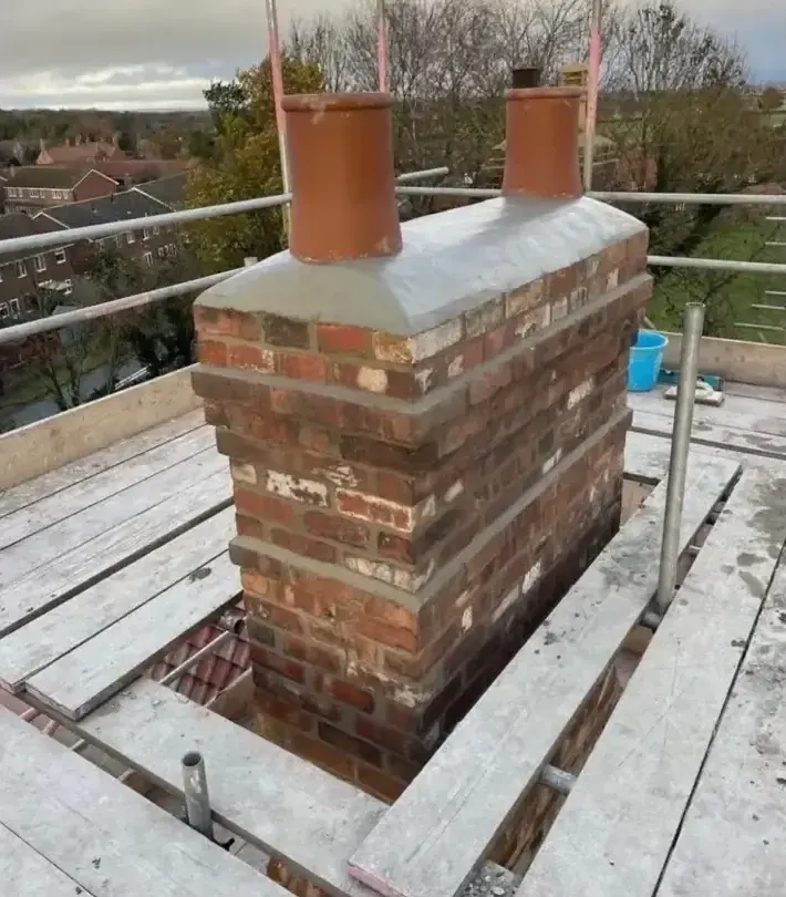 Rebuilt brick chimney stack with new clay pots and fresh flaunching by DJW Roofing & Leadwork